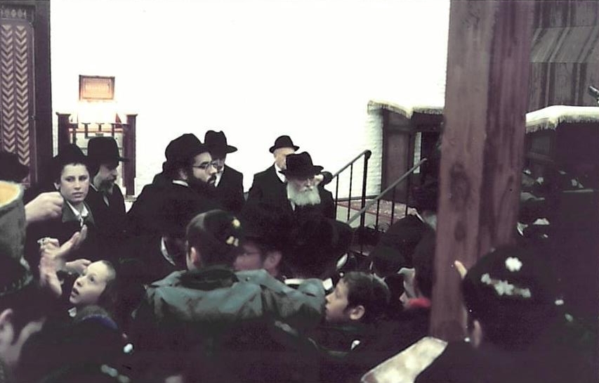 ניתן לראות מאחורי כ"ק אדמו"ר מלך המשיח שליט"א את הרה"ח ר' זלמן ע"ה יפה
